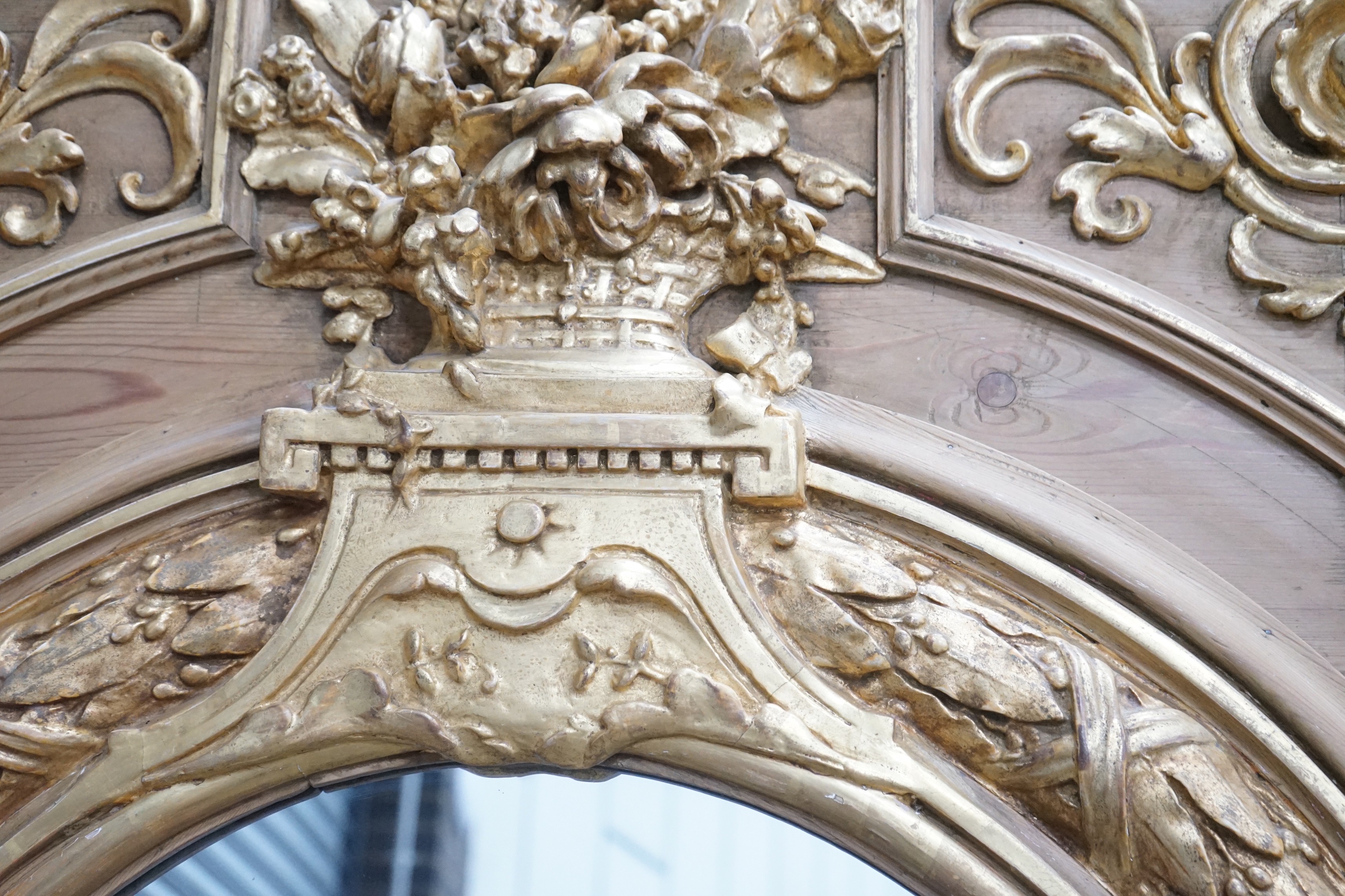 A Victorian pitch pine and gilt composition wall mirror the arched plate with floral vase surmount, width 117cm, height 212cm